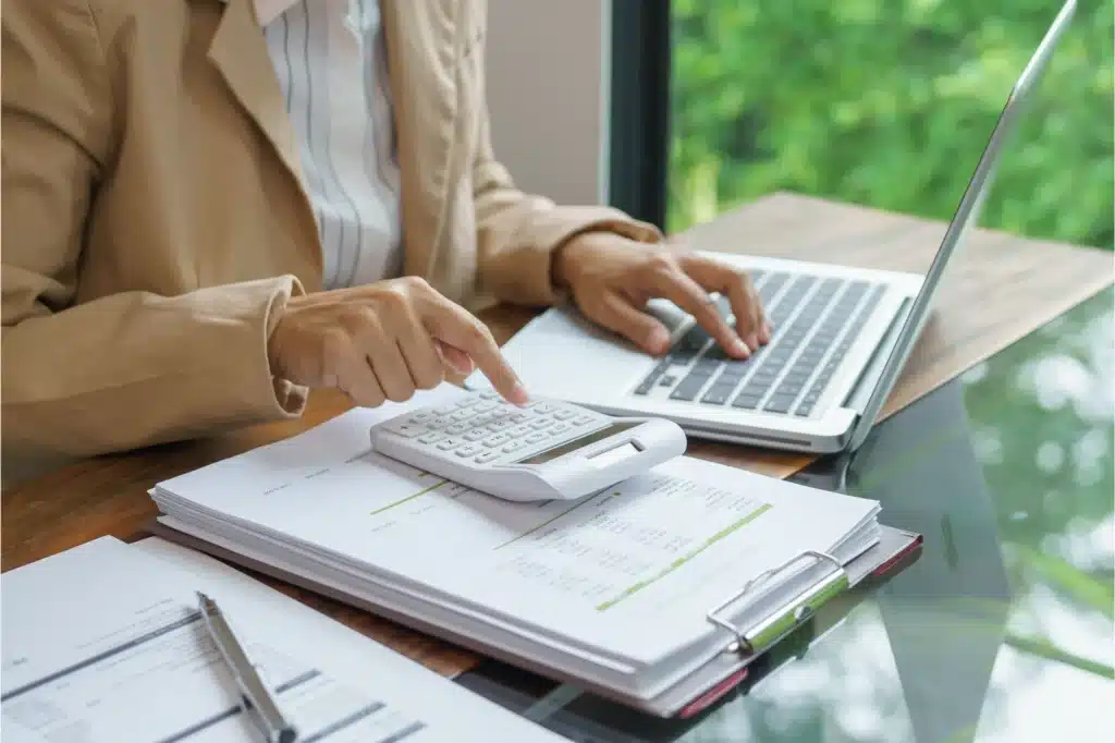 Calculating addiction treatment costs with documents and laptop