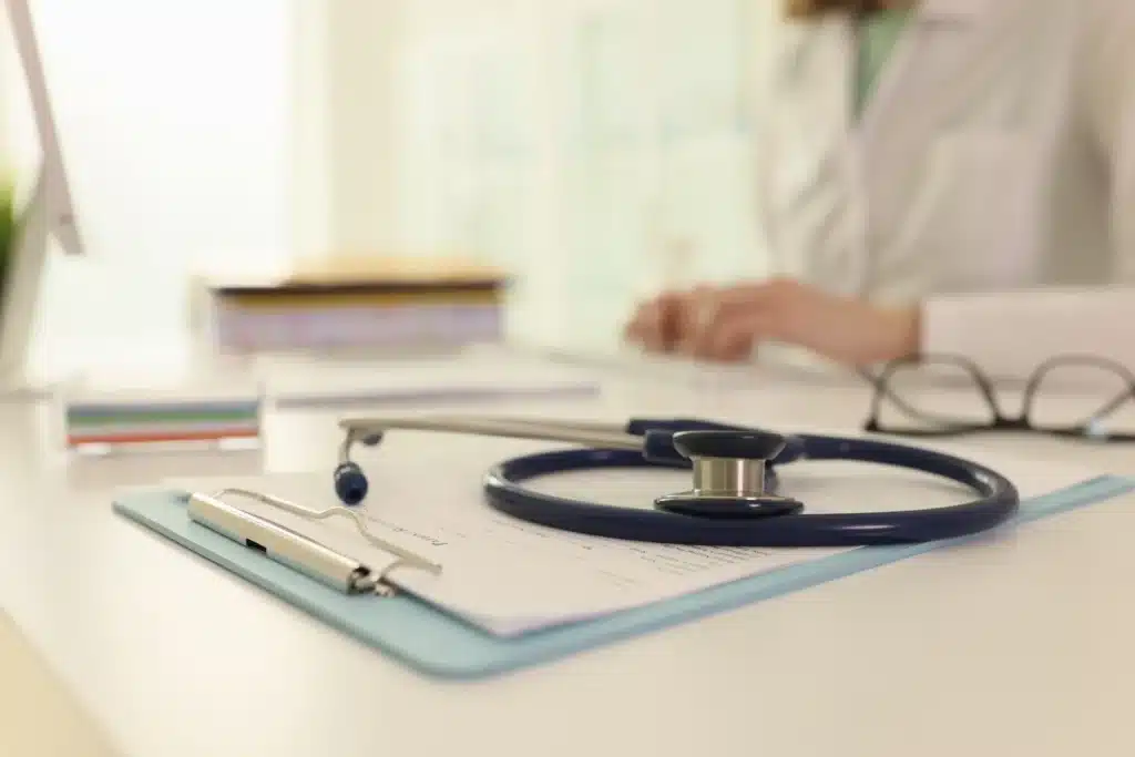 Close-up of a stethoscope and patient intake forms on a clipboard in a medical office, symbolizing professional detox and clinical care for alcohol treatment.