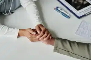 Two hands holding in support