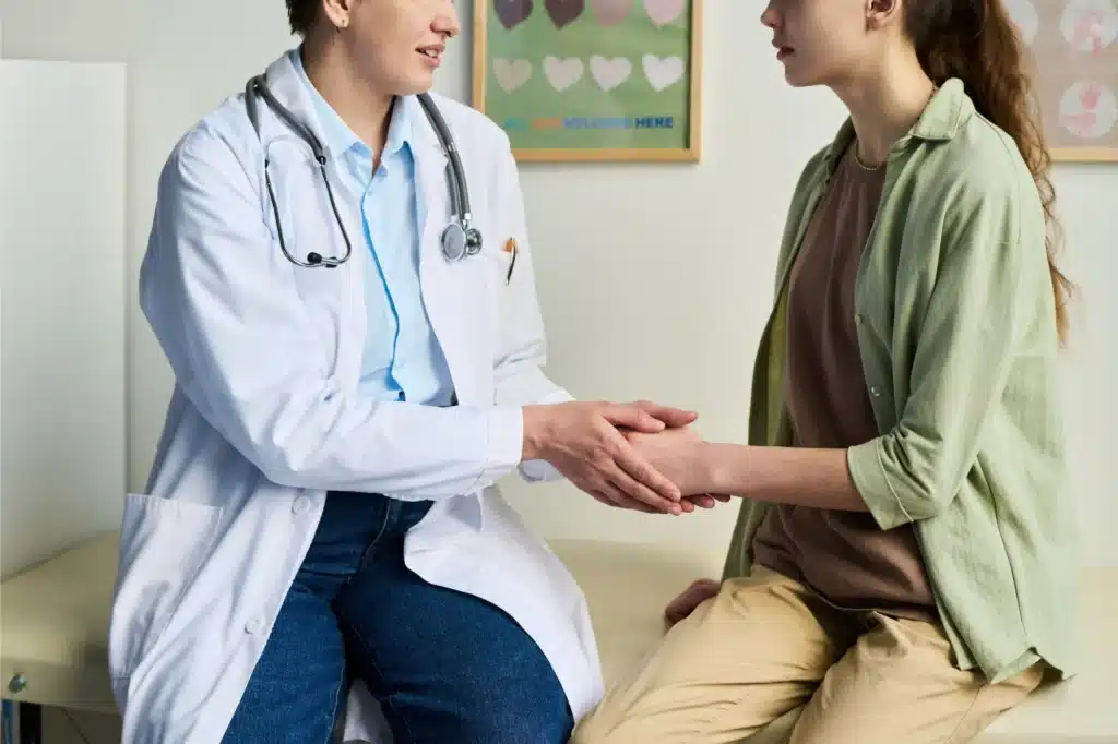 Medical doctor sitting with a patient discussing medical treatment.