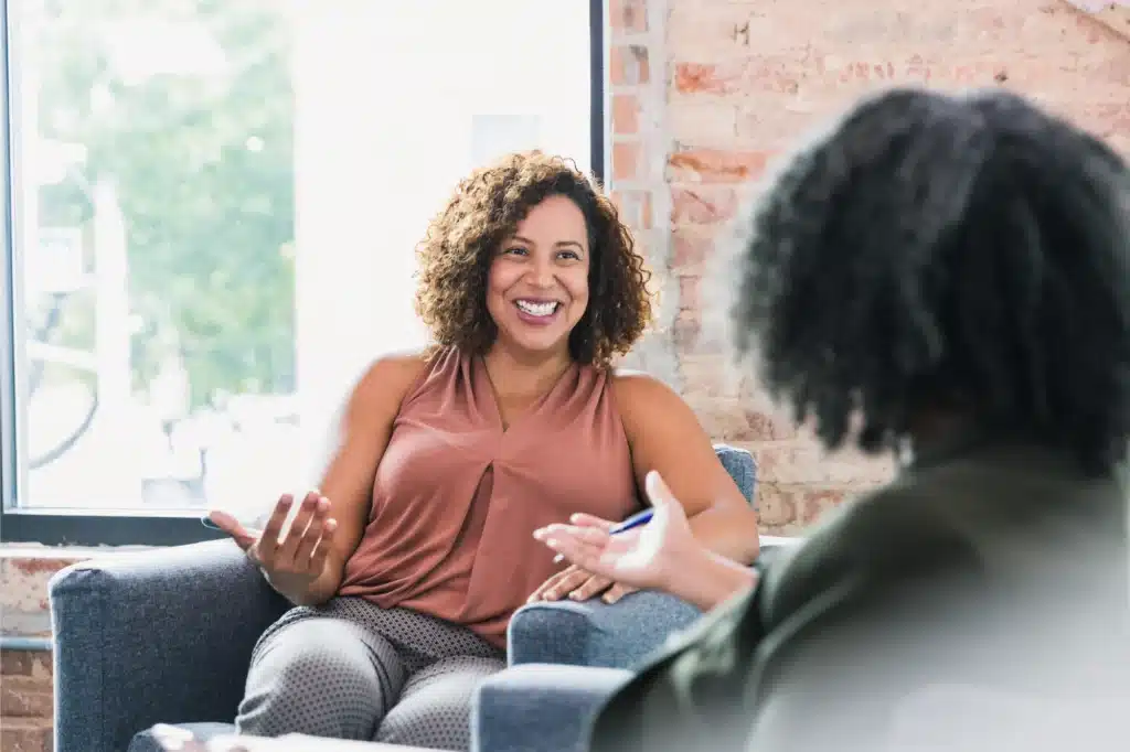 Two women engaged in outpatient therapy conversation.