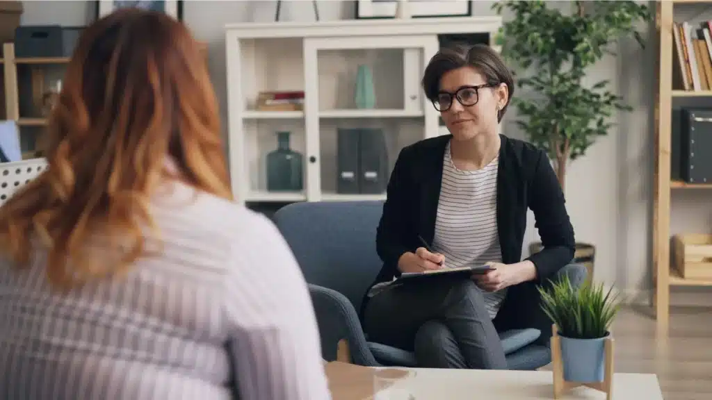 Therapist conducting a one-on-one counseling session with a client in a trauma-informed drug rehabilitation setting.