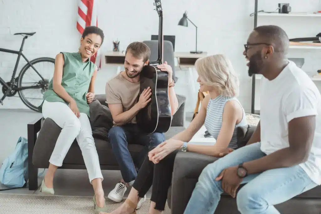 Group of diverse young adults smiling and bonding during peer support in alcohol rehab program in New Jersey.