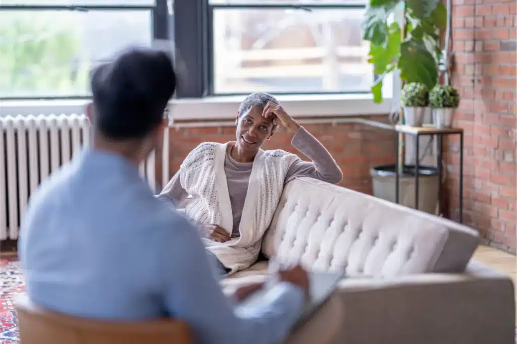 Older woman talking with a therapist during a counseling session in a calm, comfortable office.