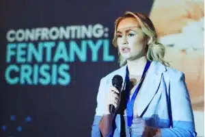 Public health speaker presenting on the fentanyl crisis at an awareness event.