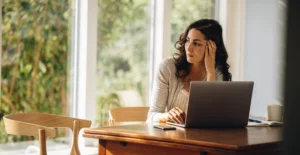 Woman sitting at a laptop while researching dual diagnosis treatment options in New Jersey.