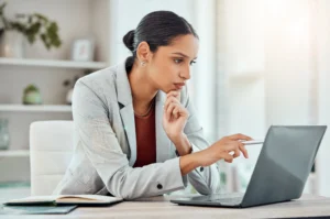 Woman researching addiction treatment options in New Jersey on a laptop while reviewing support resources online.